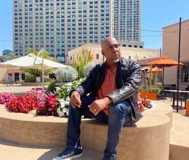 Lee A Jones sitting on a concrete bench in front of a building