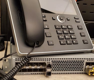 VoIP desk phone on top of a network device