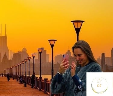 photographie corrigée, femme souriante regardant son portable sur un fond de lumière dorée et sur un bord de fleuve calme