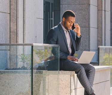 a man in a suit and tie is sitting on a ledge