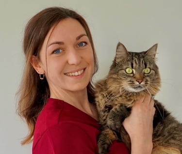 a woman in a red shirt is holding a cat