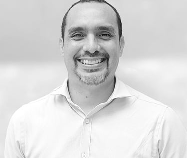 un hombre con camisa blanca sonriendo en foto blanco y negro