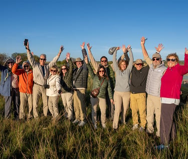 A groups of travelers with their hands in the air, men and womenprovided by Tauck Travel