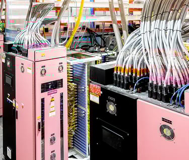 Industrial server racks with organized high-voltage power cables in a modern data center facility.