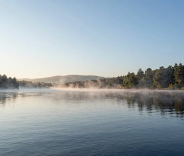 Landscape photography of a serene North American / US lake at dawn, mist rising from the water, clean and sophisticated composition, cool blue and Warm Off-white colors.