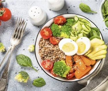 Colorful bowl with avocado, egg, broccoli, tomatoes, grains, and fresh greens for holistic nutrition