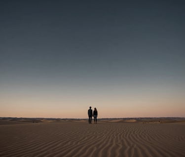 A wide-angle landscape shot of a North American desert at dusk, with a lone couple standing under a charcoal sky, deep horizon line, cinematic and sophisticated.