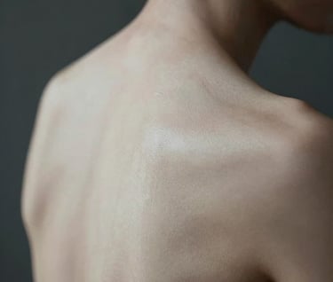 Artistic macro photography of the human form, focusing on the organic textures and lines of the skin. Soft lighting in a dark room, charcoal and off-white tones, North American style.