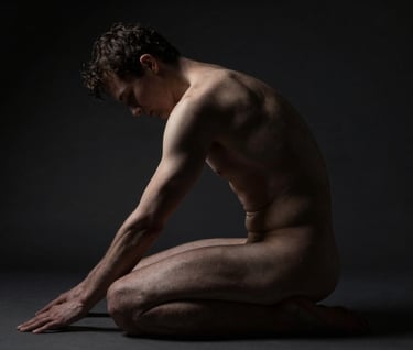 An artistic low-light study of the human form seated in a contemplative pose. Deep shadows dominate the composition, while subtle off-white highlights define the arch of the back and the curve of the shoulder. Professional photography in a North American / US studio.