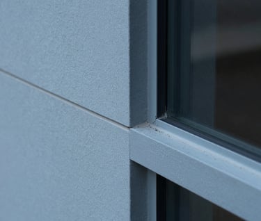 Macro detail shot of smooth Slate Blue concrete and glass joinery. Precise architectural finish, minimalist and conceptual, soft side light, European Portuguese design quality.