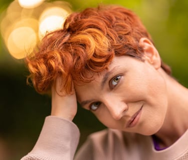 a woman with red hair and a pink sweater
