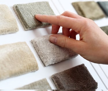 a person's hand holding a piece of carpet with a finger on it