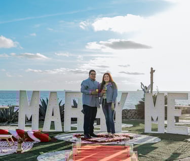 a man and woman standing in front of a sign that says marry me