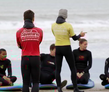 two surf coaches giving a safety brief while group listens.