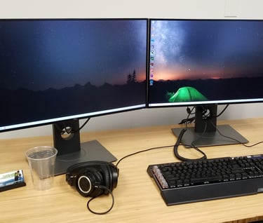 a desk with two monitors and a keyboard