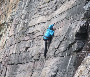 a person climbing a rock face on a cliff