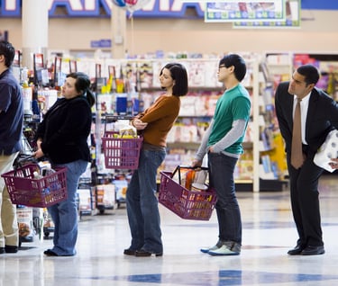 um grupo de pessoas em pé na fila de um supermercado