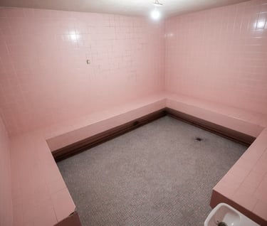 Pink sauna room set at Grayfox Studios featuring tiled walls, cozy lighting, and vibrant aesthetic