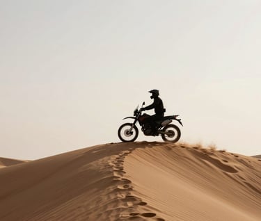 A silhouette of a lone rider on a motorcycle at the crest of a sand dune in a Global / Western desert. The sky is a pale, soft off-white, creating a high-contrast profile. Edgy and storytelling-focused.