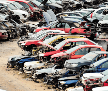 A bunch of old cars parked in a Surrey junkyard