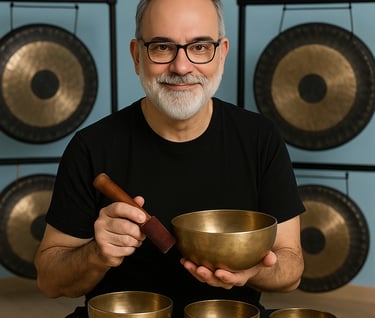 a man with a beard and glasses holding a bowl of singing bowls