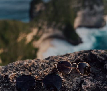 a pair of sunglasses and sunglasses on a rock