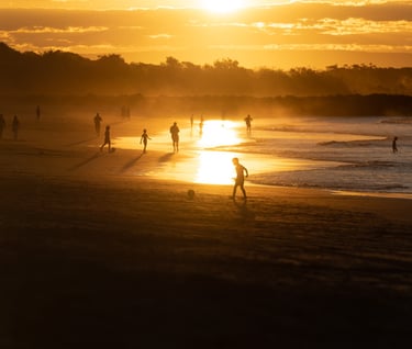 a person walking on a beach at sunset