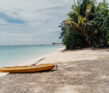 a yellow canoe sitting on the beach