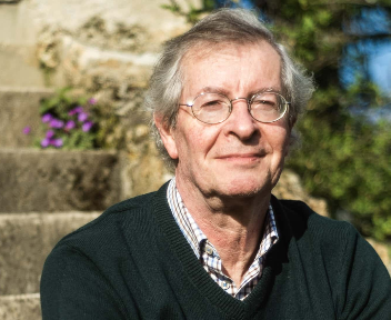 a man in a sweater and glasses is smiling
