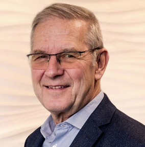 a man in a suit and glasses smiling