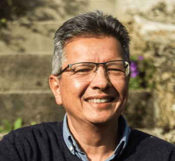 a man with glasses and a sweater sweater