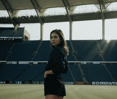 a woman in a black dress standing in a stadium