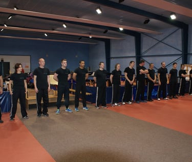 a group of people standing in line with their hands on their hips krav maga