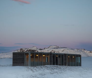 a small cabin with a view of mountains in the distance