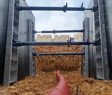 XpressJack quick shoring system supporting a trench during pipe and cable laying installation.