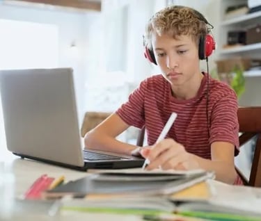 a boy with headphones and headphones on a laptop