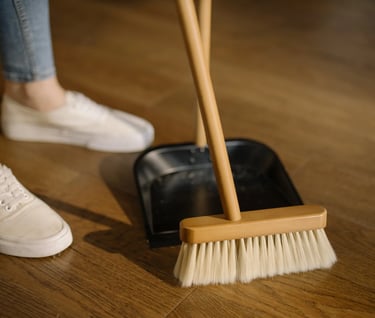 a person standing on a wooden floor with a broom and a broom