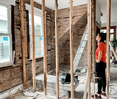 a woman standing in a room with a ladder