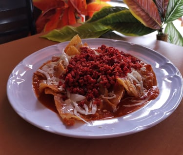 Un plato de chilaquiles rojos con chorizo