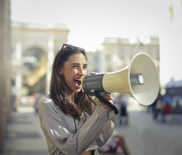 a woman with sunglasses and sunglasses is holding a megaphone