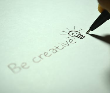 a person's hand is writing a lettered notepad