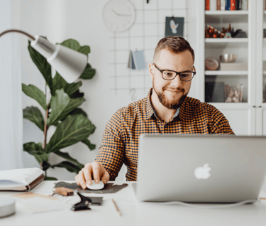 a man sitting at a desk with a laptop computer