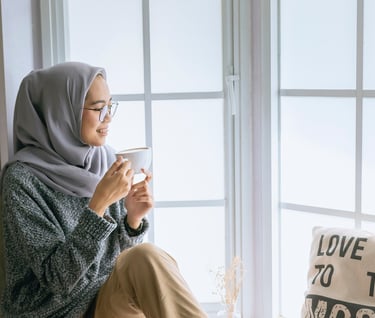 A beautiful girl with Good daily habits for better mental health enjoying her coffee by the window