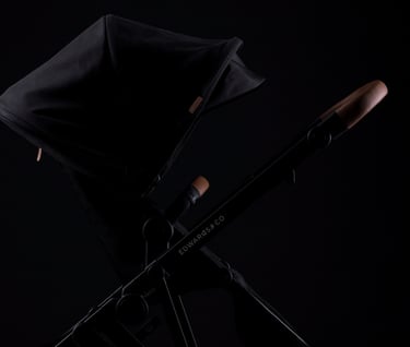 Product campaign photography - a black baby stroller with removable seat and brown leather handles