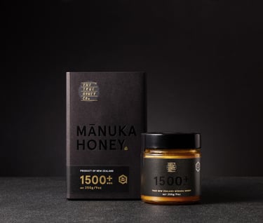 Product photography - a jar of honey sitting beside the packaging on a black background