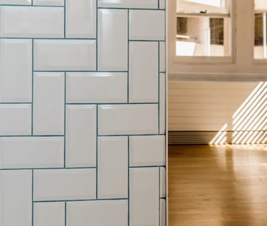 a white tiled bathroom with a white tile floor