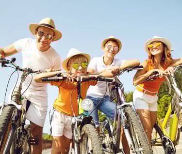 a family of three people riding bikes on a sunny day
