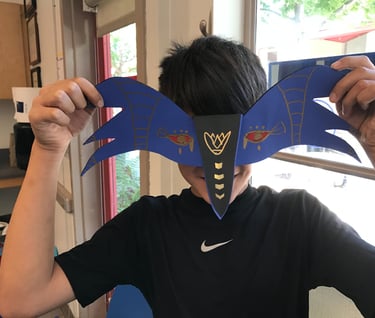 student holding mask in front of face