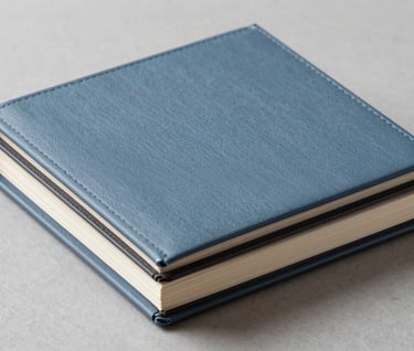 A stack of elegant social event albums, slate blue covers with charcoal black accents, professional product photography, clean composition.