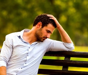a man sitting on a bench in a park need to write his cv